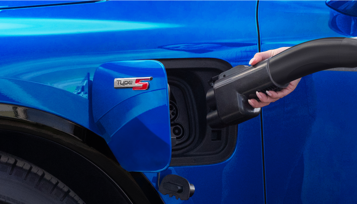 Vue latérale du port de charge du véhicule, du câble et de l'adaptateur.