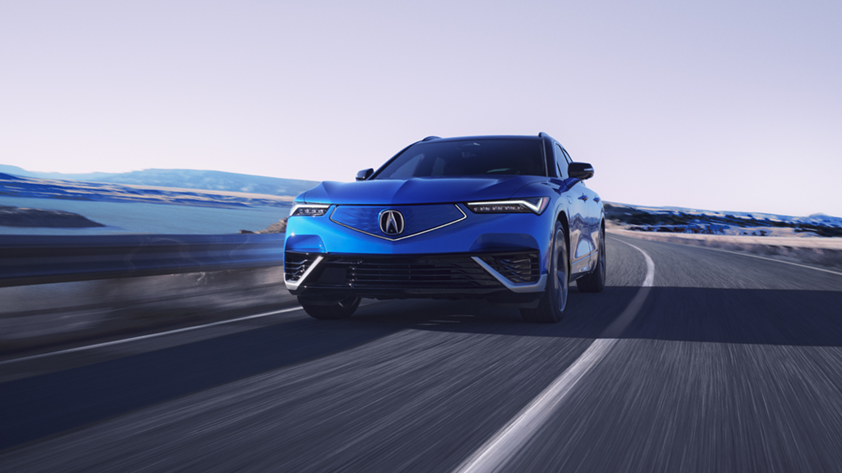 Wide front view of blue ZDX on highway driving toward camera.