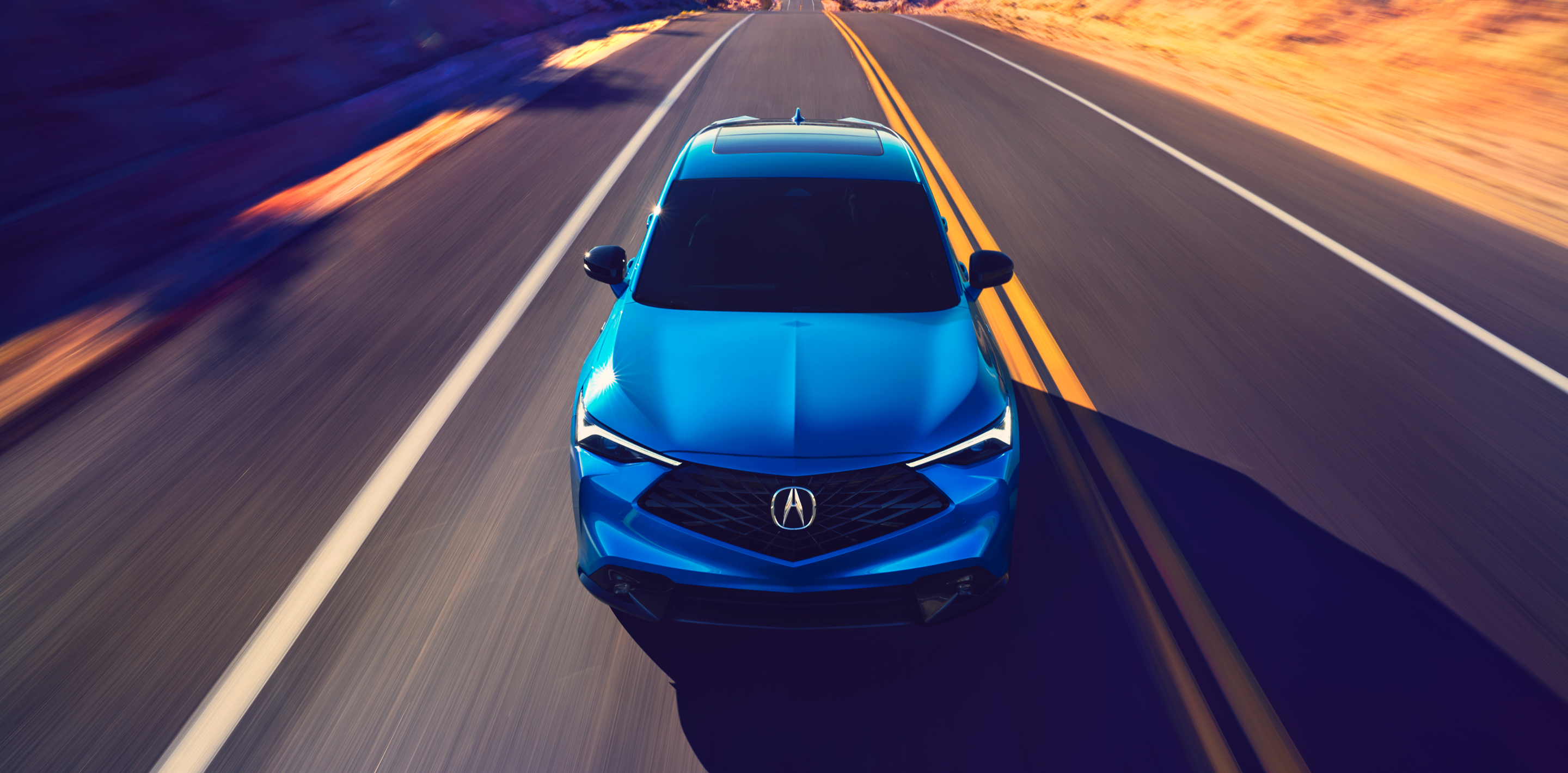 Front view of a blue Acura ADX on the highway