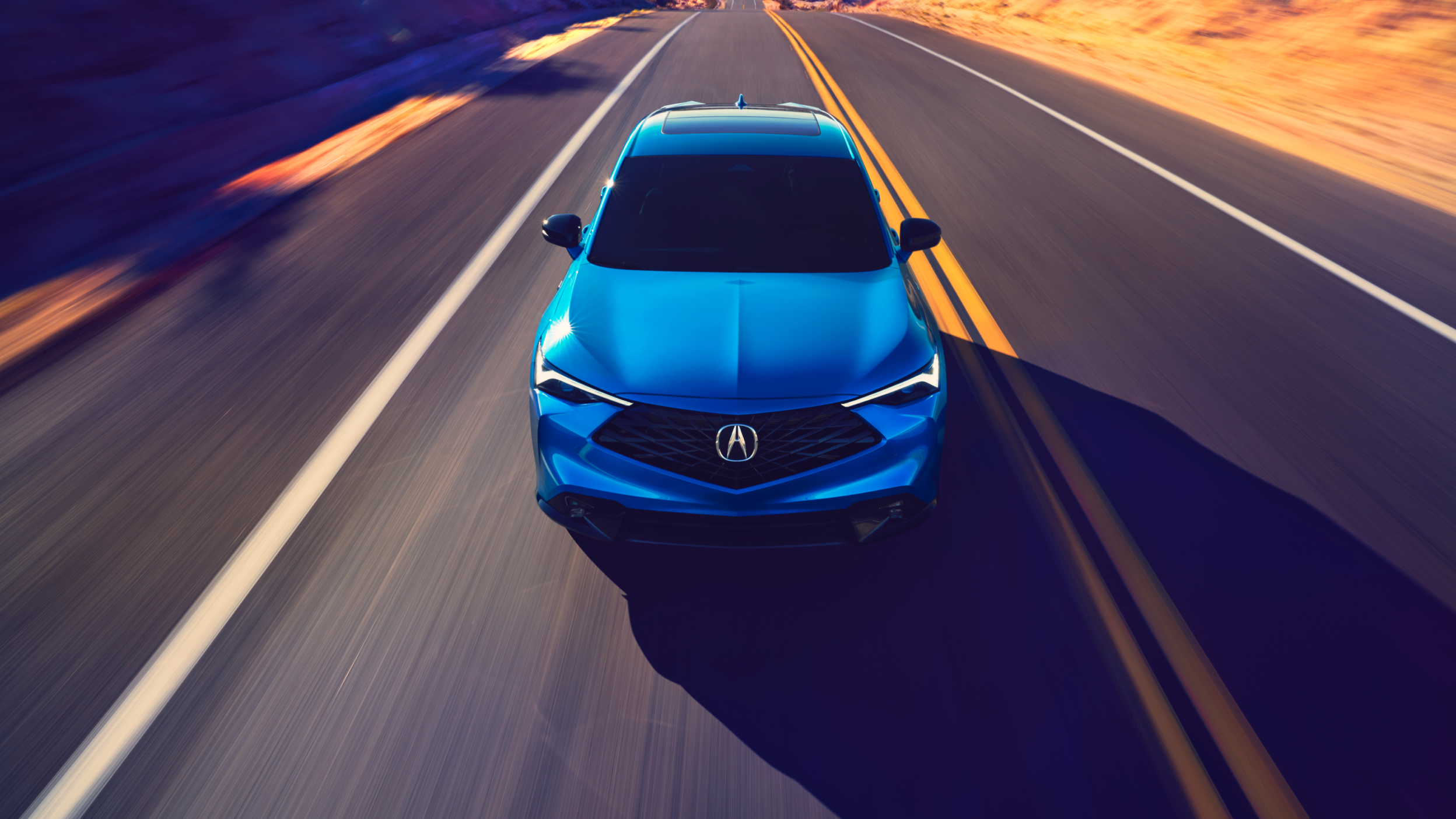 Front view of a blue Acura ADX on the highway