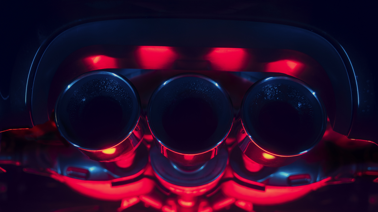 Closeup of the triple centre exhaust on an Integra Type S saturated in red and blue light.