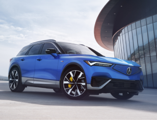 Vue 3/4 avant du ZDX bleu stationné à l'extérieur d'un bâtiment moderne en verre au coucher du soleil.