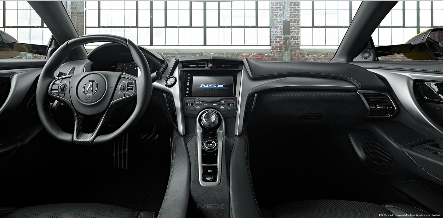 The interior of an Acura's cockpit from the backseat. /  	Vue du cockpit d’une Acura à partir de la banquette arrière.